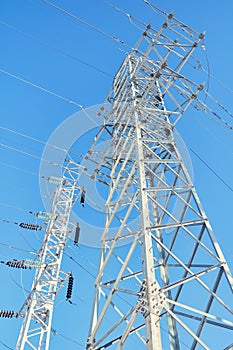 Supports high-voltage power line against a clear blue sky.