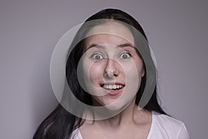 Suprised brunette woman, isolated on gray background. happy actress portrait. human emotions, facial expression concept