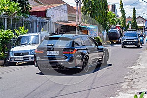 Black BMW M3 Competition Touring xDrive G81 on the road