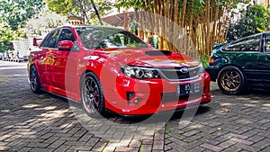 Red Subaru WRX STI sedan in car meet