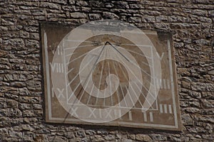 Sure a stone facade of a house, a sundial