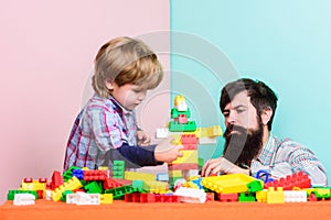 Surefire ways to bond with your son. Dad and kid build plastic blocks. Child care development and upbringing. Father son