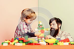 Surefire ways to bond with your son. Dad and kid build plastic blocks. Child care development and upbringing. Father son