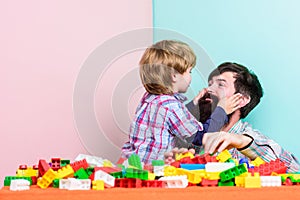 Surefire ways to bond with your son. Father son game. Dad and kid build plastic blocks. Child care development. Family photo