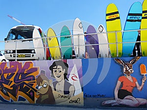 Surf boards and an old van by graffiti painted wall