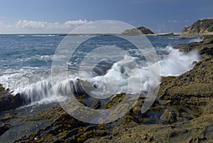 Surf breaking on rocky coastal tide pool