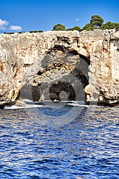 Surf bridge with eroded rock masses behind the surf throat on the rocky coast of Mallorca