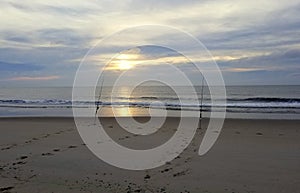 Surf fishing rods on the sandy beach on an early morning