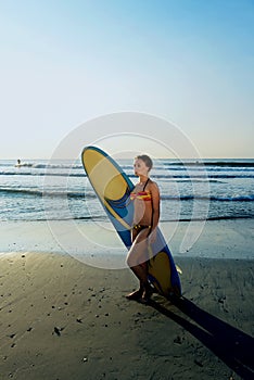 Surf girl looking out at blue ocean