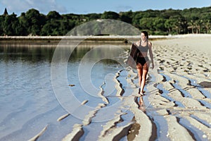 Surf girl with surfboard on the beach