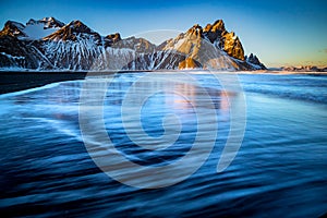 Surf glides over the black sandy beach in Vestrahorn