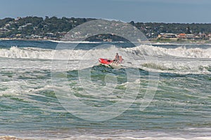 Surf rescue life savers training in progress. Surf rescue boat jumping on the waves at Wanda Beach,