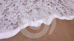 Surf rolling in side of sandy beach