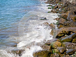 Surf. Waves crash on big rocks. Rocky coast and wave. Powerful coastline. Sea foam. The excitement of the sea. Huge coastal rocks