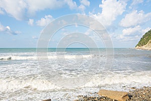 Surf with waves on the shore. Beautiful summer sky