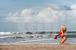 Surf woman with long blonde hair go to ocean.