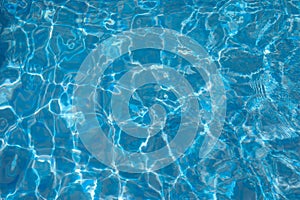 Surface of Blue ripped water in the swimming pool. Background of water in the swimming pool.