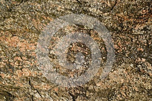 The surface of a chipped granite stone in warm sunny colors