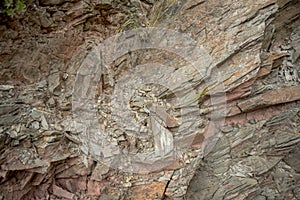 surface of cracked natural stone in which the reddish tones predominate