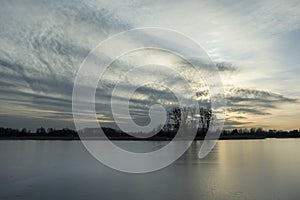 The surface of the frozen lake and clouds after sunset