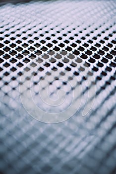 Surface of latticed metal fence. Stainless steel and aluminum light blur background. Macro texture