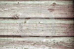 A surface made of wooden planks, on which knots and cracks are clearly visible. Horizontal stripes. Grey colour