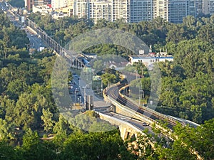 Surface metro. Modern train moving on rails above the ground in the city. Subway cars traveling across the bridge, outdoors. New