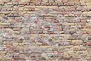 Surface of the old brick wall of red and yellow bricks, bonded with cement mortar