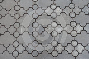 Surface of pavement of curved grey interlocking concrete tiles