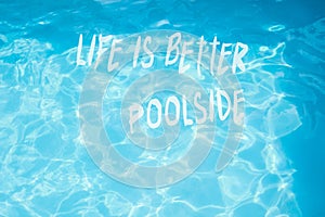 Surface of  pool water with quote life is better poolside