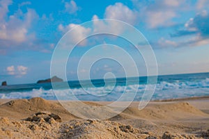 surface of sandy beach with blurry sea background as the horizon