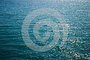 The surface of the sea water. Background texture of a calm deep blue ocean with ripples