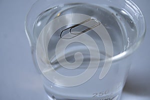 Surface tension of water. Paper clip floats on water in the laboratory