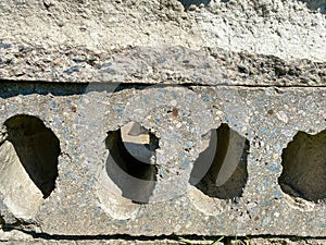 Surface texture of solid gray construction concrete cement slab with holes. The background