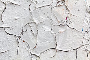 Surface texture with white paint and cracks on concrete wall. For abstract backgrounds