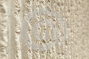 Surface of the wall with a decorative white plaster. Textured concrete wall with vertical lines and stripes as a texture or backgr