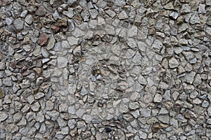 Surface of wall with light gray gravel pebble dash