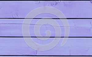 Surface of wooden boards painted with lilac paint. Wooden background painted trendy color of the year 2022 Very Peri