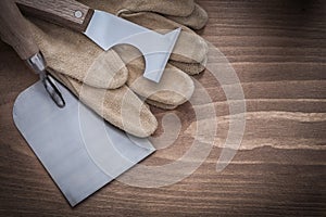 Surfacer bricklaying trowel and leather construction gloves on w photo