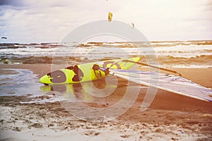 Surfboard on the beach, kitesurfing in the background