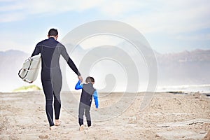 Surfboard, man and child on beach, holding hands and mountain on outdoor bonding adventure. Nature, father and son at