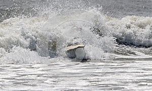 Surfboard in rough water after surfer wipes out and falls