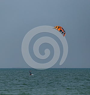 A surfboard is surfing on the sea near the long bridge in Pattaya beach of eastern in Thailand on a long holiday
