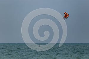 A surfboard is surfing on the sea near the long bridge in Pattaya beach of eastern in Thailand on a long holiday