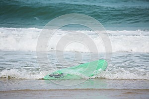 a surfboard washed ashore by a wave