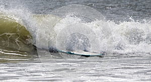 A surfboard in a wave after the surfer fell off