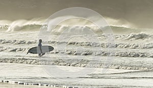 Surfer approaches Waves, Fistral Beach, Cornwall photo