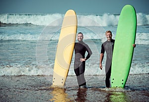 Surfer beginner and instructor on a beach with a surfboards photo