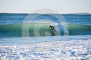 Surfer on Blue & green Ocean Wave riding a surfboard