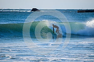 Surfer on Blue & green Ocean Wave riding a surfboard